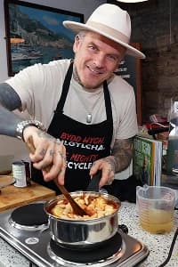 Matt stirring a saucepan filled with vegetables on a hob