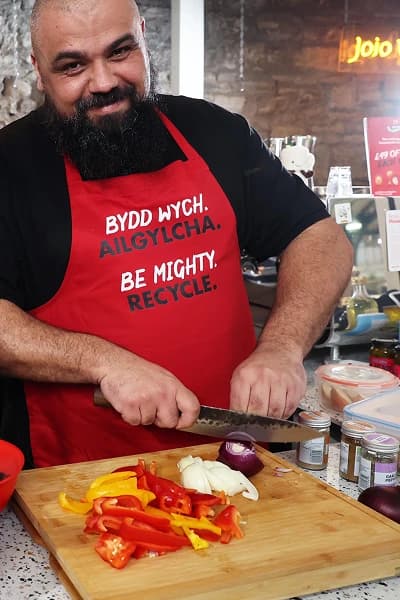 Chris slicing vegetables on a chopping board in the kitchen
