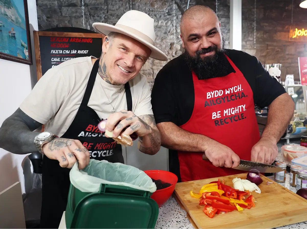Matt and Chris smiling while cooking together in a kitchen