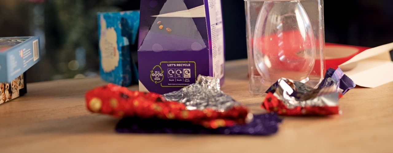 Easter Egg packaging on a table - including foil, plastic inserts and cardboard boxes.