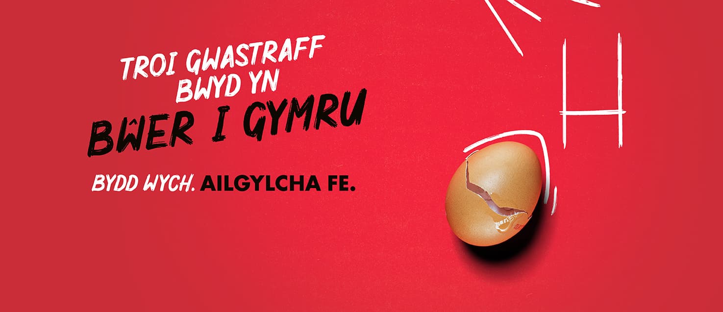 Cragen wy wedi cracio gyda physt rygbi wedi'u tynnu â sialc a choed ar gefndir coch gyda'r slogan "Troi gwastraff bwyd yn bwer I Gymru. Bydd wych. Ailgylcha fe."