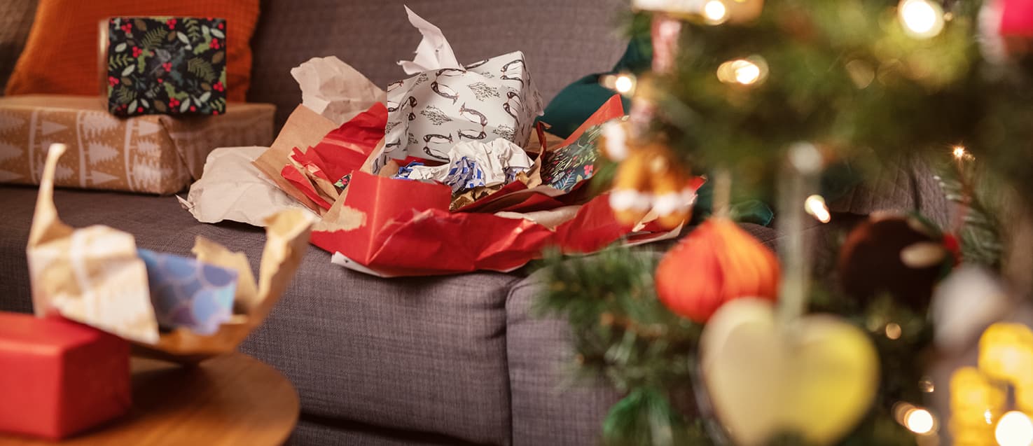Scrunched Christmas wrapping paper on a sofa in a decorated lounge